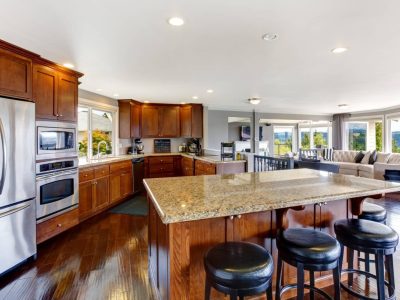 Spacious luxury kitchen room interior with kitchen island and black stools.